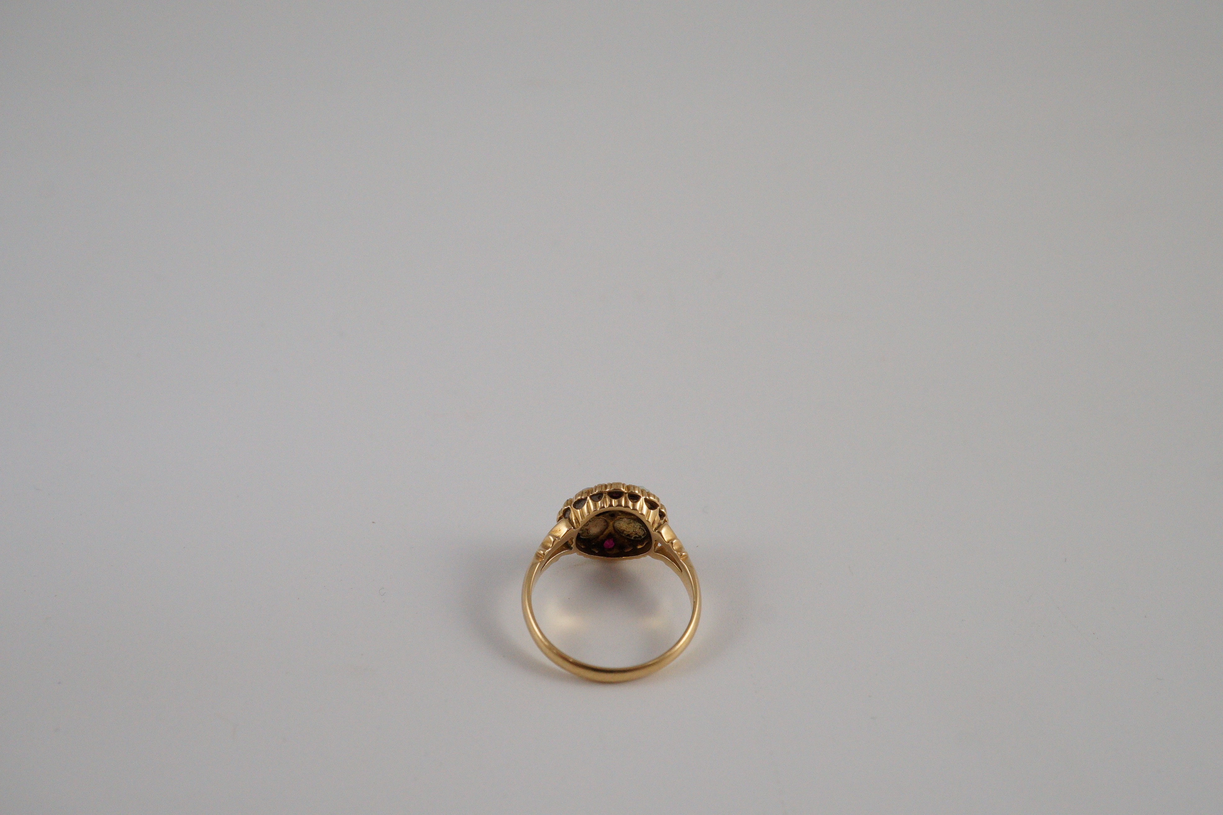 An Edwardian 18ct gold, ruby, white opal and diamond set circular cluster dress ring